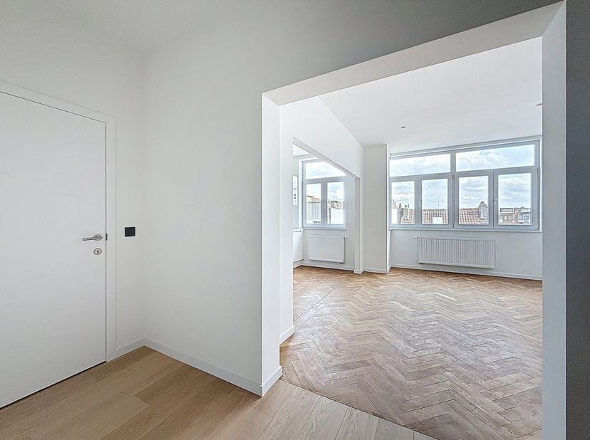 Op een steenworp afstand van Altitude 100 en de Molièrelaan, in een mooi karaktervol gebouw, gerenoveerd appartement van 91m2. Woonkamer met prachtige
