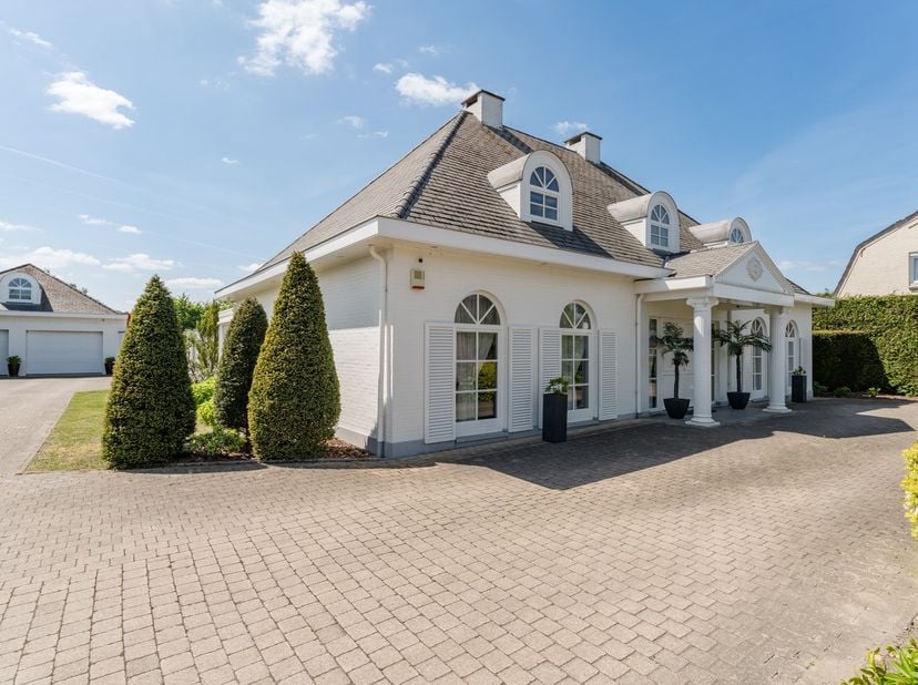 Dit  statige landhuis in Amerikaanse stijl gelegen op 2780 m² grond inclusief bijgebouw en buitenzwembad vinden we terug op de Fabrieksstraat te Pelt,