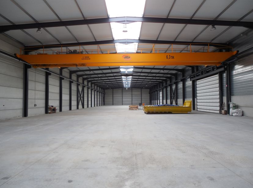 Dit verzorgde bedrijfsgebouw te huur, bestaande uit een ruim magazijn met kantoren, is gelegen in de industriezone Zaubeek bij de afrit Kruisem van de