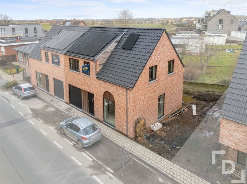 Lot 2  is een halfopen woning - die duidelijk herkenbaar is door het gebogen raam -  waardoor er een autostaanplaats en ook een inpandige garage aanwe
