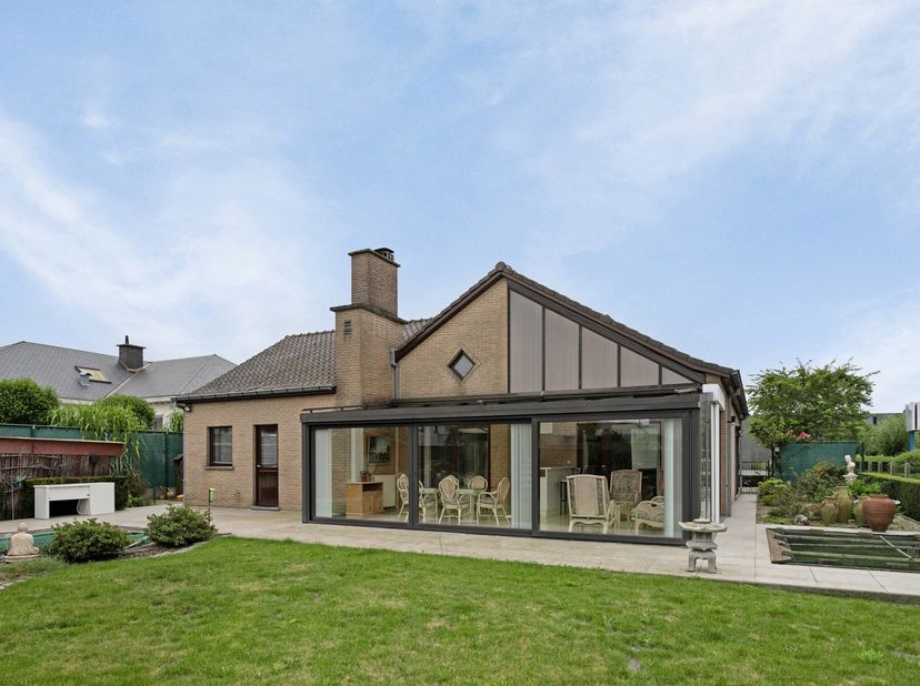 Zeer ruime villa met alles op het gelijkvloers ! Bestaande uit hal met apart toilet en vestiaire, ruime en super gezellige living met houthaard. Aansl