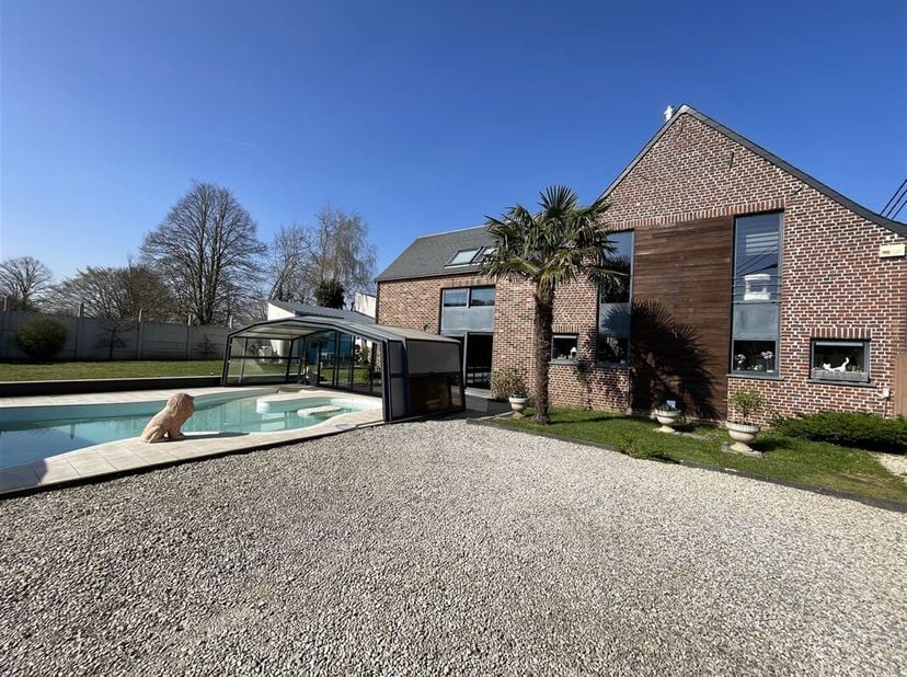 Ontdek dit prachtige huis in Doornik, een juweeltje van moderne architectuur dat comfort en elegantie combineert. Met 300 m² woonoppervlakte biedt dez
