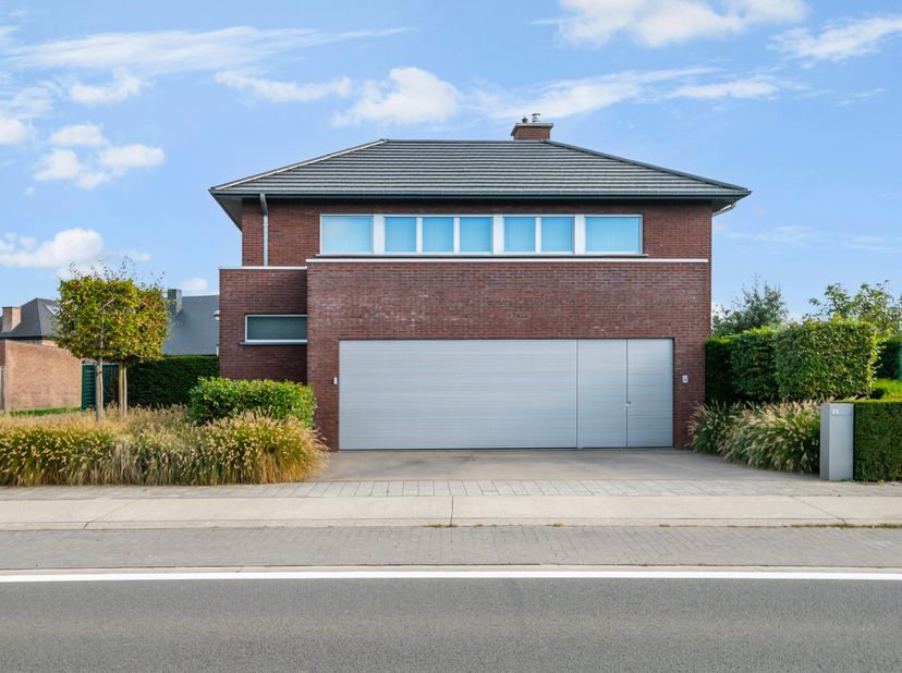 Deze hedendaagse en met hoogwaardige materialen afgewerkte villa biedt u een stijlvolle inkomhal met apart toilet, een zeer lichtrijke en knusse zitho