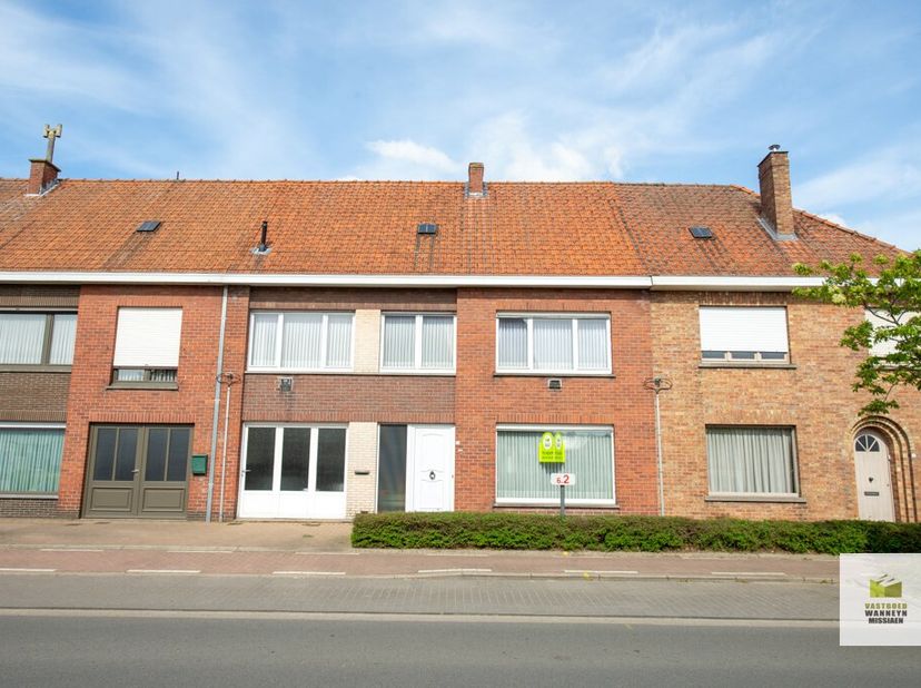 Zeer centraal gelegen ruime woning met garage en tuin. De woning  heeft volgende indeling: inkomhal, ruime living, keuken, garage, kelder, veranda en