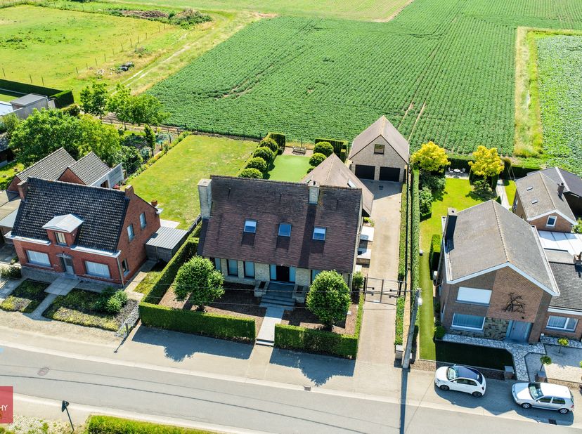Standingvolle eigendom bestaande uit een inkomhall, bureel (of gelijkvloerse slaapkamer), grote living met open haard, ingerichte keuken met eetruimte