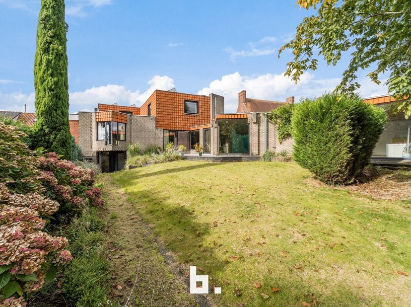 Deze unieke, bijzonder ruime (404m²) architectenwoning met binnenzwembad en loods bevindt zich op een zonovergoten perceel (1577 m²) pal in het centru