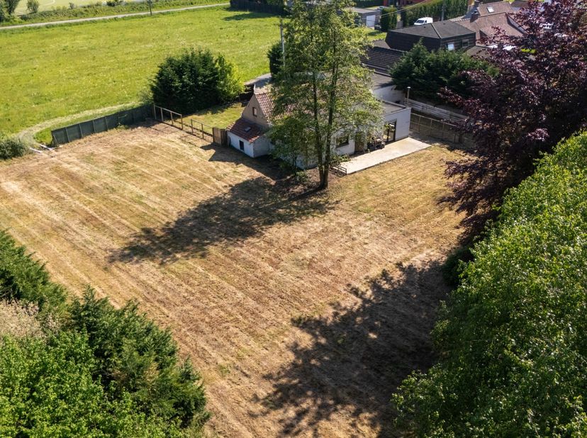Nabij de Karmel te Waregem, ligt deze te renoveren woning met ruim bijgebouw op royaal perceel grond op het einde van een doodlopende straat. Privacy