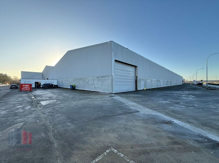 Riant bedrijfsgebouw van +-15.000 m² met magazijnruimte en kantoren te huur op uitstekende locatie op amper 800m van de Steenweg Deinze (N35). Momente