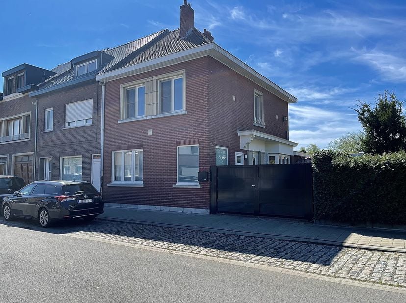 We betreden de woning via de voordeur aan de zijkant, via de zwarte poort met ruime oprit. De inkomhal is voorzien van een gastentoilet. &lt;br /&gt;
Achter