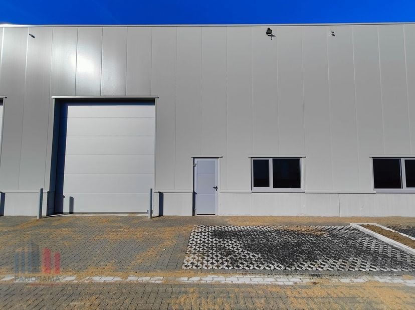 De casco loods van 333 m² heeft een vrije hoogte van 6 m en is opgebouwd uit een staalstructuur met betonplint in combinatie met geïsoleerde sandwichp