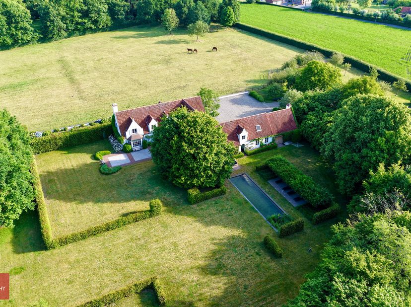 Bestaande uit inkomhal, living met parket en open haard, eetplaats, zeer ruime leefkeuken (arch. X. Donck) met eethoek en open haard (barbecue), tv-ho