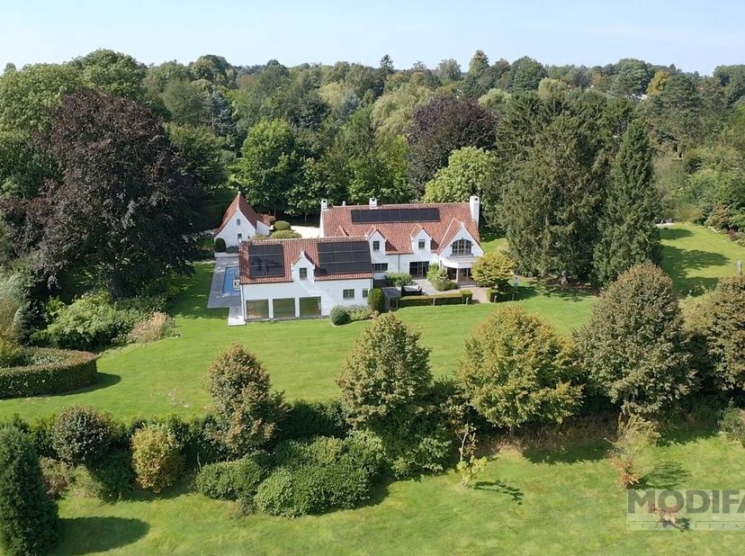 Op de achtergrond, uit het zicht, sfeervolle familiewoning met bijgebouw (conciergerie, kantoor, guesthouse).&lt;br /&gt;
Woonkamer met parketvloer, erker e
