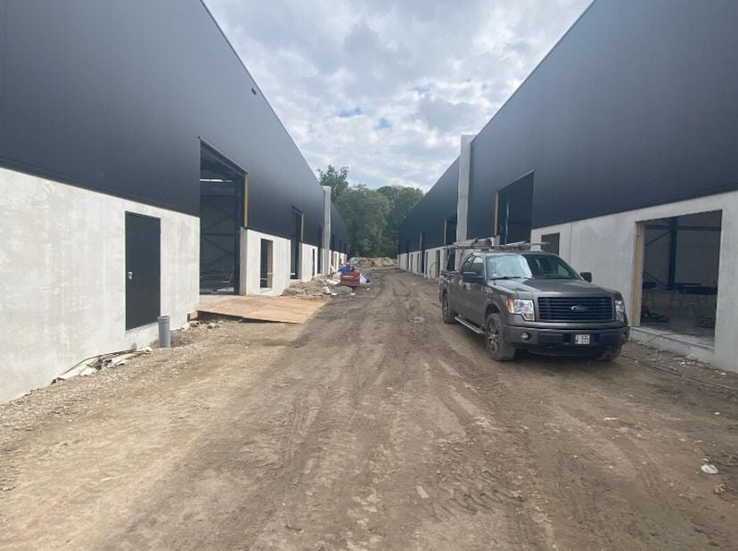Te huur in Buggenhout: nieuwbouw KMO-unit vanaf 160 m², 6m vrije hoogte en polybetonvloer. Voorzieningen omvatten een sectionaalpoort, parkeerplaatsen