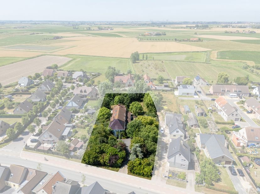 Gelegen in het gezellige Vlissegem vind je deze te renoveren villa, verscholen in het groen en bereikbaar via een lange oprijlaan, wat zorgt voor extr