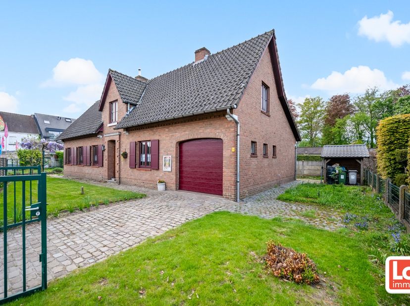 Deze goed onderhouden, op te frissen, woning bestaat op het gelijkvloers uit een ruime inkomhal met houten trap (en stoellift), een ruime lichtrijke w