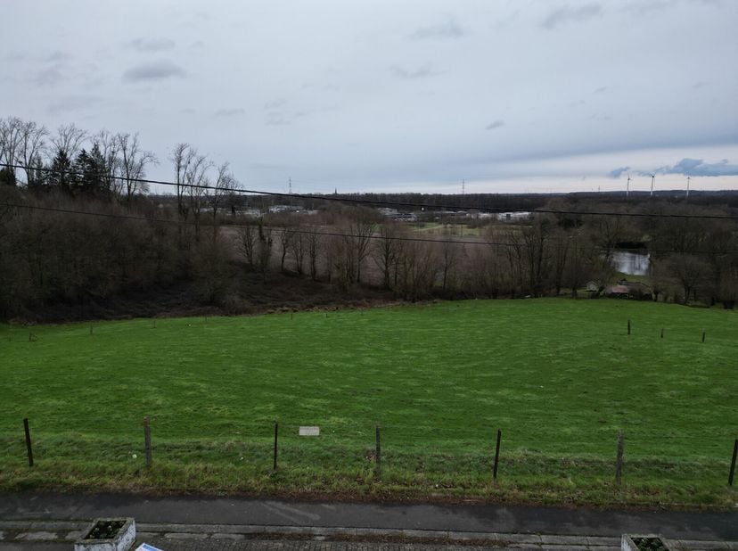 Ce terrain spacieux offre une grande façade à rue (environ 31 m) et une vue magnifique sur une prairie ouverte et un bosquet, parfaite pour les amoure