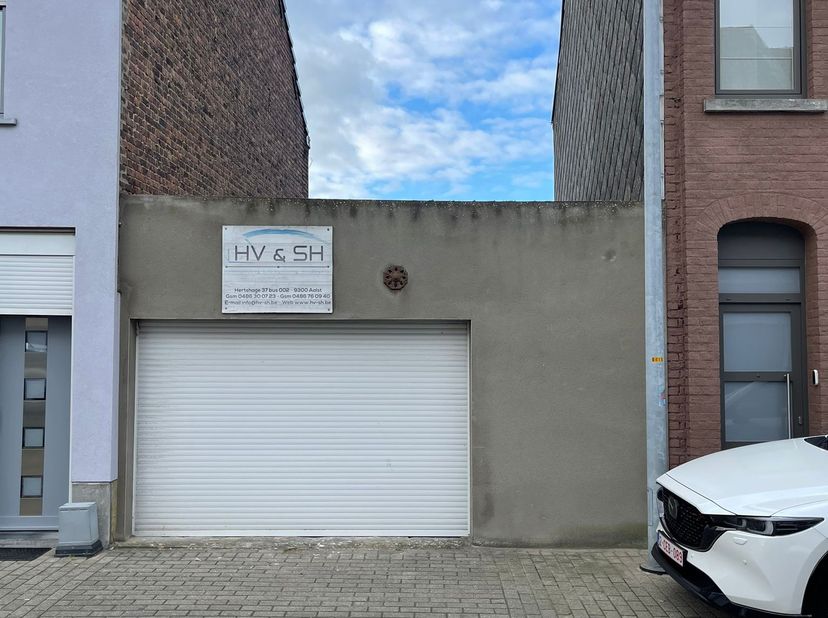 Garage te koop, met achterliggend klein stuk grond. De garage is 30 m² met een deur die aanpaalt op een klein tuintje van 7 m². Er is elektriciteit aa