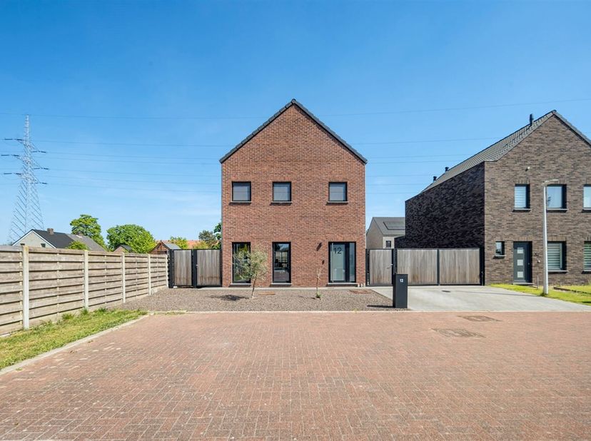 Bij het betreden van de woning komen we terecht in de inkomhal die toegang biedt tot het gastentoilet, de trap naar de eerste verdieping en de leefrui