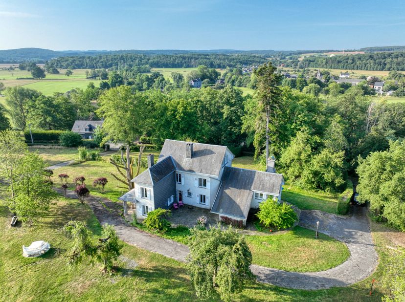 Nichée en retrait de la voirie principale, sur les hauteurs du village, cette maison de maître de caractère séduira les amateurs de charme, despace et