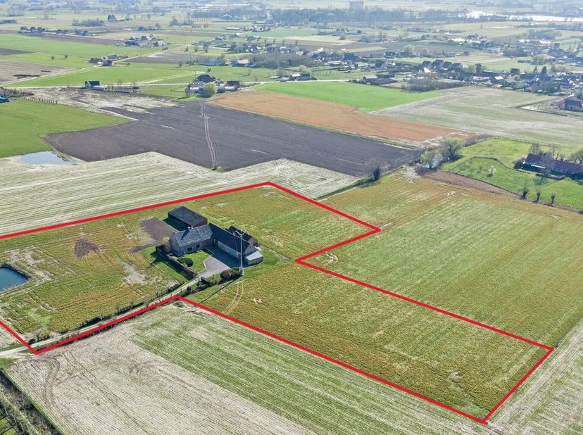 Aan het einde van de doodlopende Koekuitstraat in Woumen bevindt zich deze charmante hoeve, omgeven door akkerland, op een perceel van bijna 2,7 ha.&lt;b