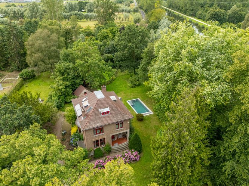 Deze prachtige, instapklare interbellum villa met art-deco-inslag is gelegen te Tildonk op een perceel van circa 30 are. Door de inrijpoort aan de voo