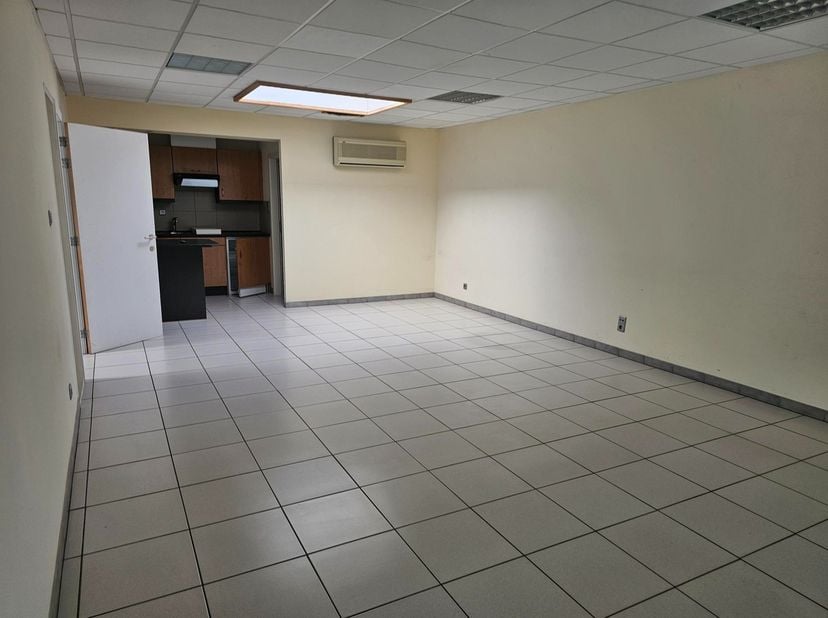 Dit pand is gelegen in een gebouw met diverse kantoorruimtes en gemeenschappelijke inkomhal. Het is ingedeeld in een kantoorruimte met open keukentje