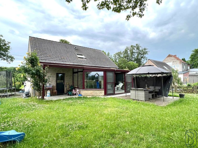 Villa met 3 slaapkamers, garage, parkeerplaatsen en prachtige tuin. Deze ruime woning omvat: Gelijkvloers: inkomhal, ruime leefruimte, open keuken, ge