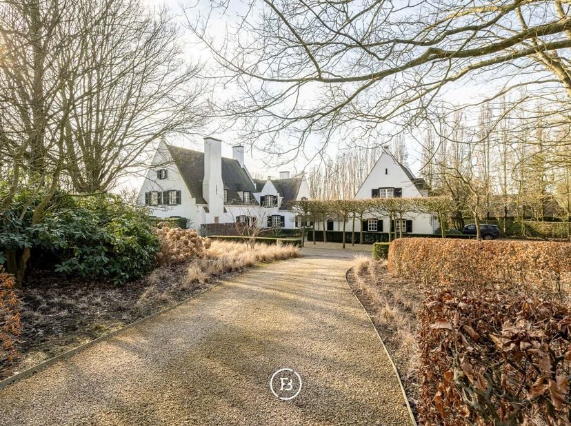 Gelegen in het groene Bellegembos vinden we dit prachtig landhuis ontworpen door Viérin. Via een discrete oprijlaan, omgeven door eeuwenoude bomen, ko