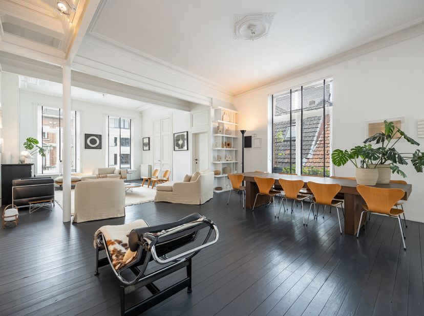 Prachtig Belle Epoque duplex met zee van licht, hoge raampartijen/plafonds en authentieke elementen. De stijlvolle ruime living/woonkamer (L.18 m-plaf