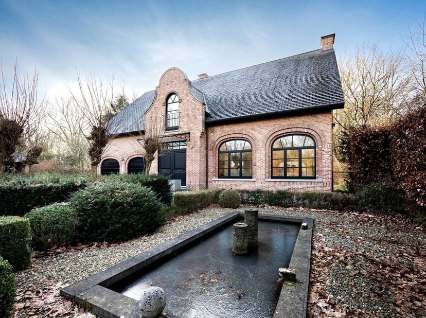 Située dans le paisible quartier de Schotenhof, entourée de chênes centenaires, cette spacieuse villa servait autrefois de conciergerie pour le presti