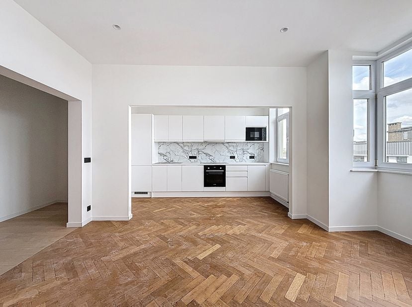 Op een steenworp afstand van Altitude 100 en de Molièrelaan, in een mooi karaktervol gebouw, gerenoveerd appartement van 91m2. Woonkamer met prachtige