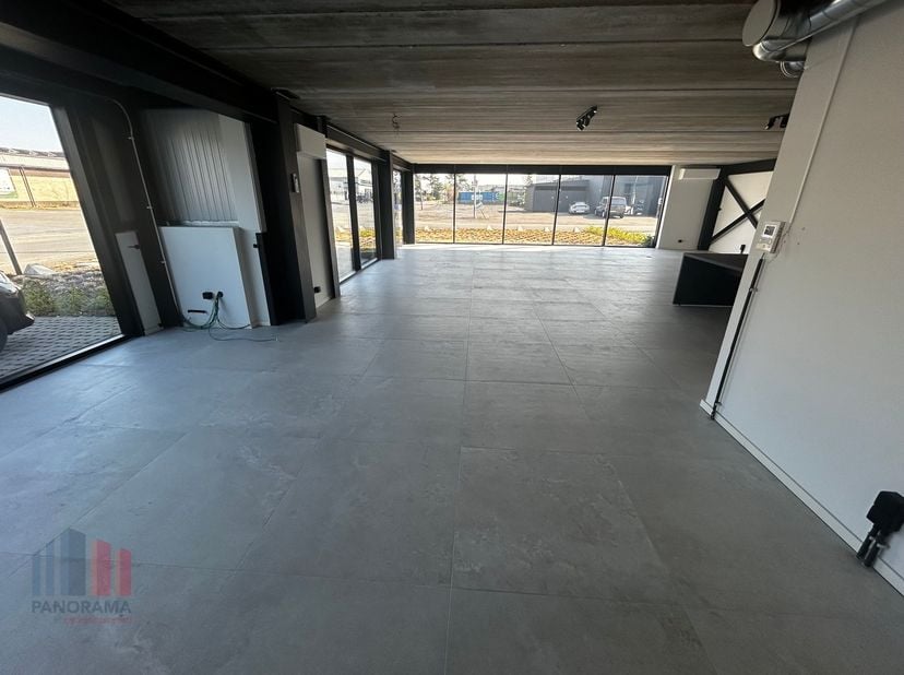 Moderne magazijnruimte van 110m² met kantoor/showroom van 145m² op het gelijkvloers. De magazijnruimte beschikt over een automatische poort en een vri