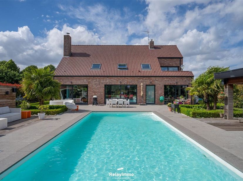Prachtig eigentijds huis op een terrein van ca. 1.900 m2 met ca. 320 m² woonoppervlak met studeerkamer, 5 slaapkamers, garage voor twee auto&#039;s, zwemba