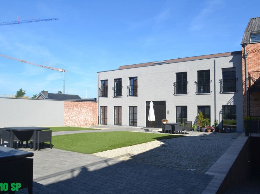Het gelijkvloers appartement heeft de volgende indeling: Ruime en lichtrijke leefruimte met sierhaard en open ingerichte keuken (kasten, koelkast, dub
