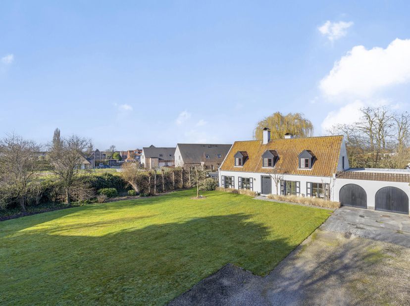 Eigendom op 7.100m² bestaande uit een grote villa met voor en achtertuin met aanpalend 2 grote magazijnen en bijhorende parking.  De villa bestaat uit