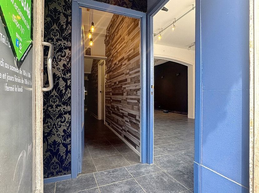 Située à proximité immédiate de toutes les commodités, cette maison de commerce rénovée développe une superficie totale de 207 m² (hors cave et cour c