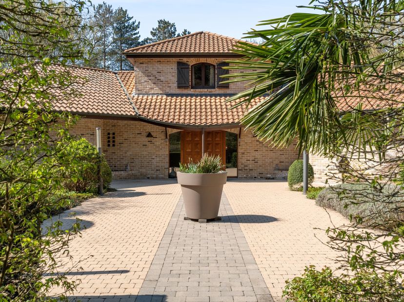 In een rustige en groene omgeving in Schoten bevindt zich deze ruime Spaanse villa op een royaal perceel van 8.670  m². Dit eigendom combineert karakt