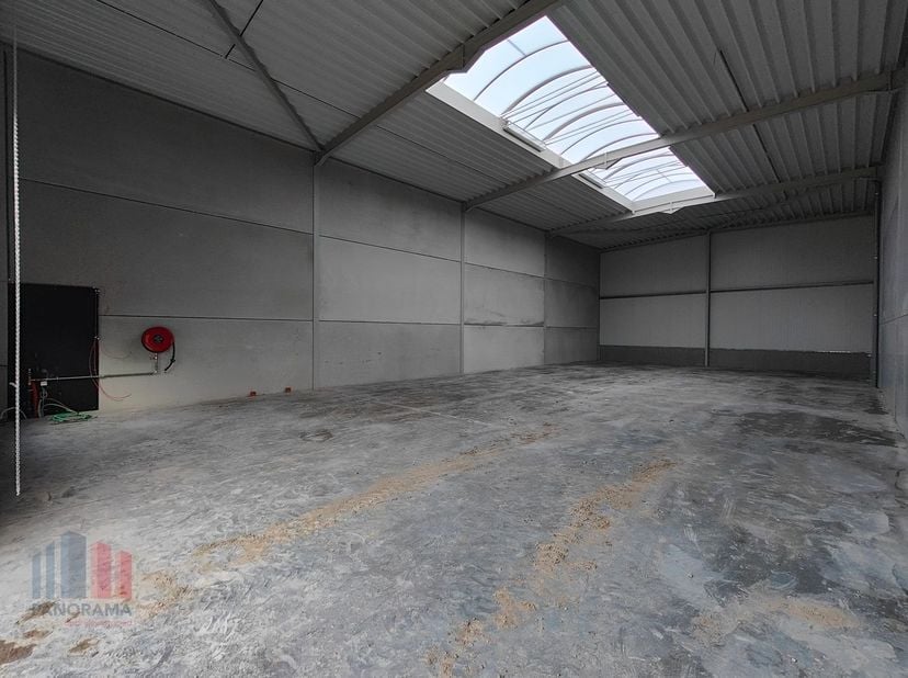 De casco loods van 219 m² heeft een vrije hoogte van 6 m en is opgebouwd uit een staalstructuur met betonplint in combinatie met geïsoleerde sandwichp