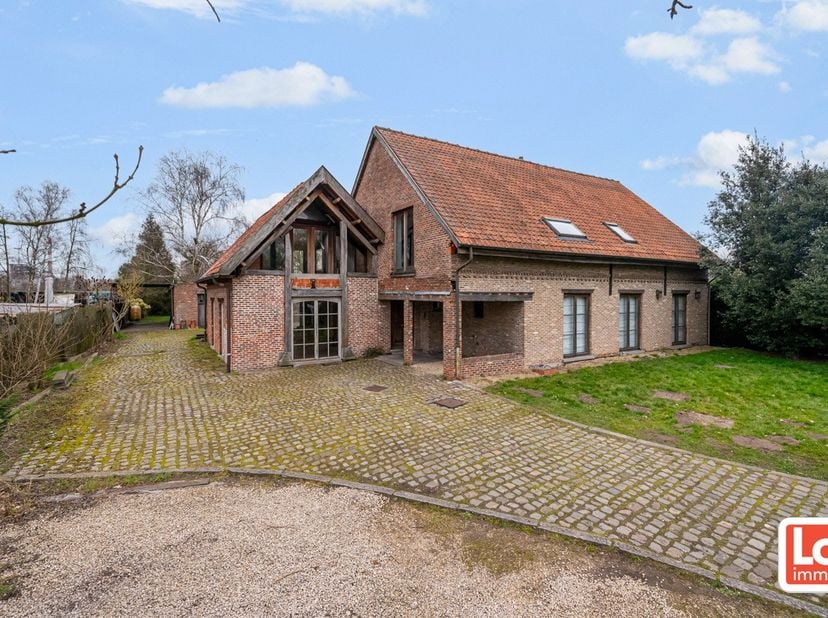 Deze ruime open woning met heel wat potentieel omvat op het gelijkvloers een inkomhal met gastentoilet, een ruime leefruimte met open keuken en aanslu
