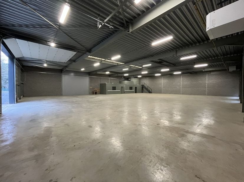 Dit bedrijfsgebouw van 750m² met een vrije hoogte van 4,5m beschikt over ingebouwde kantoren met mezzanine bestaande uit kitchenette, 2 douches en toi