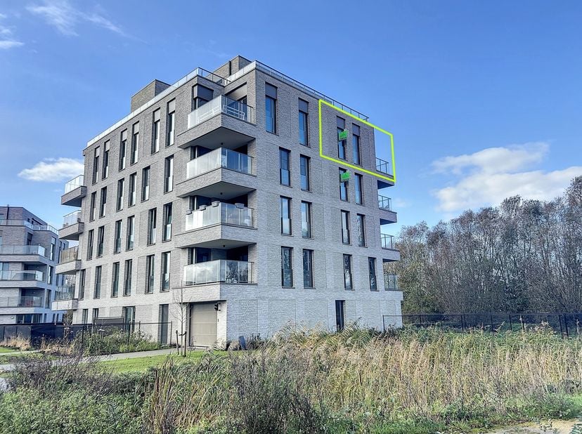 Modern en energiezuinig 1-slaapkamer appartement met zicht op groen. Het appartement omvat een inkomhal met gastentoilet, leefruimte met open keuken,