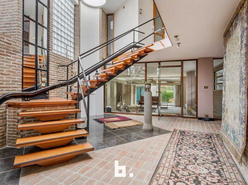 Deze unieke, bijzonder ruime (404m²) architectenwoning met binnenzwembad en loods bevindt zich op een zonovergoten perceel (1577 m²) pal in het centru