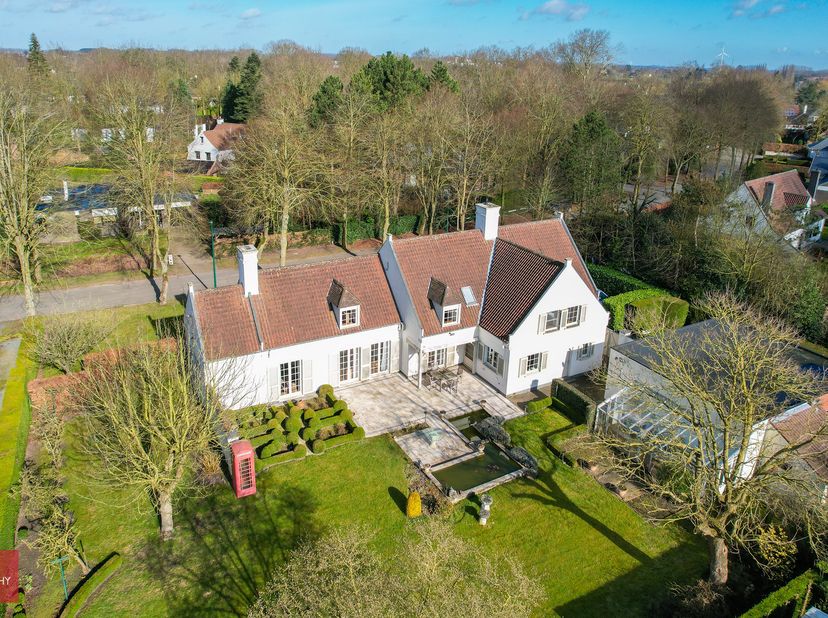 Bestaande uit inkomhal, living met zitput en prachtige open haard, eetplaats met bar, ingerichte keuken, wasplaats, bureel, 5 slaapkamers, 2 badkamers