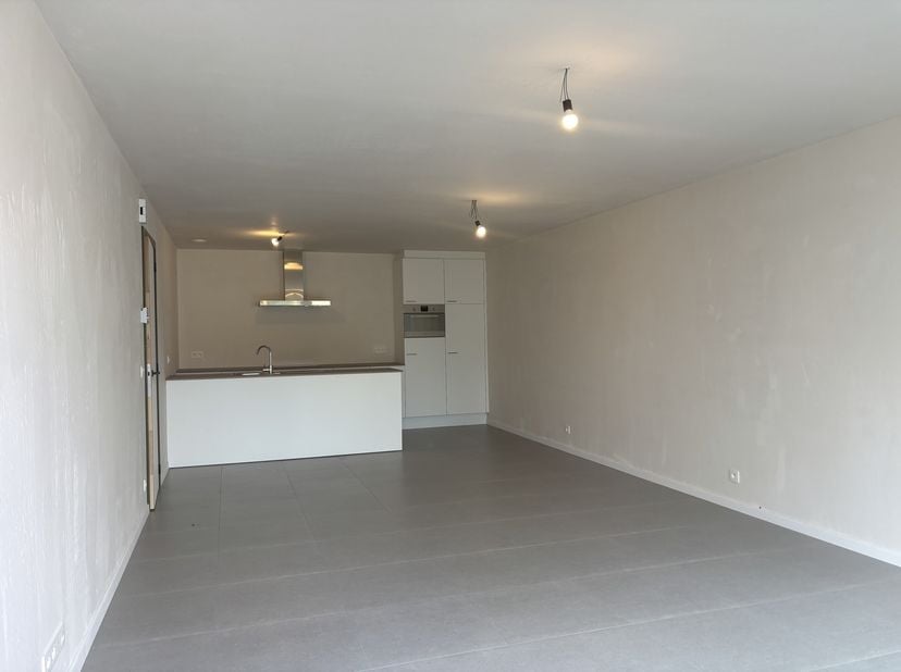 Appartement A 0,1 bevindt zich in de blok tegen de Vrijheid op het gelijkvloers helemaal links. Vooraan is een aparte inkomdeur, inkomhal en twee slaa
