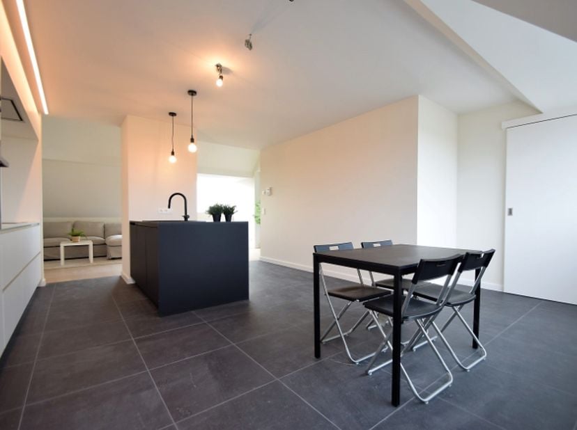 Centraal gelegen appartement bestaande uit een inkomhal met inmaakkasten, gezellige leefruimte, volledig uitgeruste luxe-keuken met eiland en eetplaat