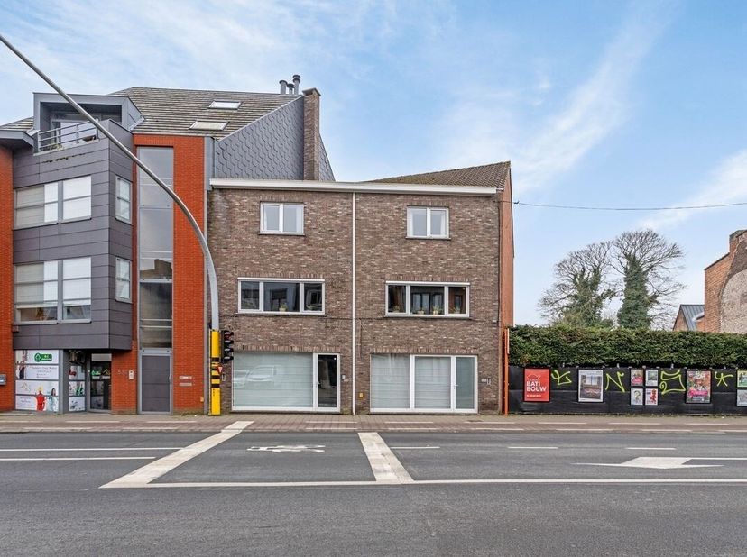 Goed gelegen commercïele ruimte met achteraan een grote werkplaats en parking met op de eerste verdieping een groot duplex appartement. Indeling: 2 wi