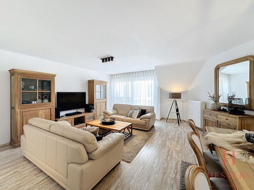 Via de lift of trap bereik je dit prachtige duplex appartement en kom je binnen in een ruime inkomhal met ingemaakte kasten.&lt;br /&gt;
Wanneer je binnenko