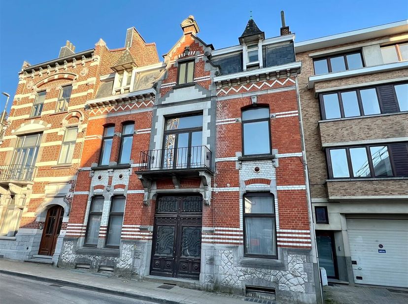 In een stijlvolle straat in het centrum van Ronse bevindt zich dit karaktervolle herenhuis vol authentieke elementen en charme. De woning biedt onder