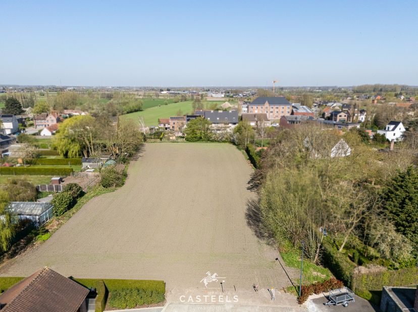 In een rustige en groene straat te Sleidinge, vlak bij het centrum, vind je dit uitzonderlijke perceel bouwgrond van 6.000 m² langs de residentiële Em