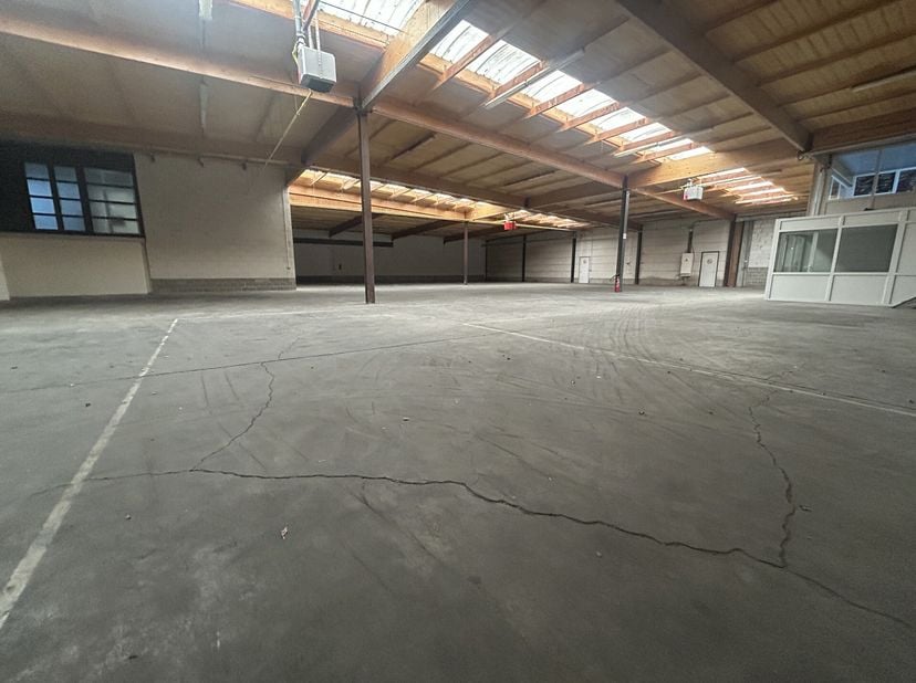 Bâtiment industriel de 1.150 m² comprenant 1.084 m² d&#039;entrepôt combiné avec 65m² de bureaux/espace polyvalente à louer. Excellente situation à proximi